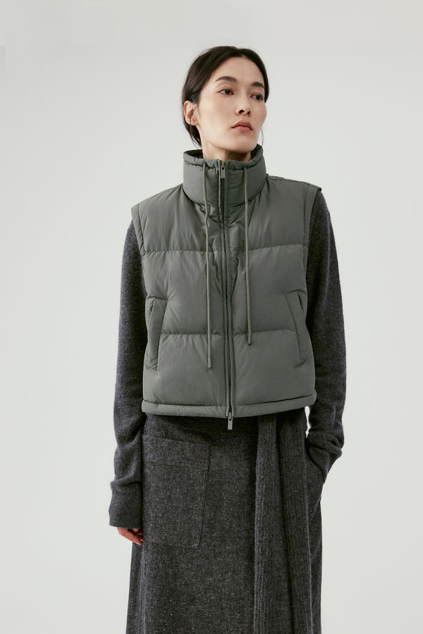 Woman wearing a quilted vest over a knit dress in fall